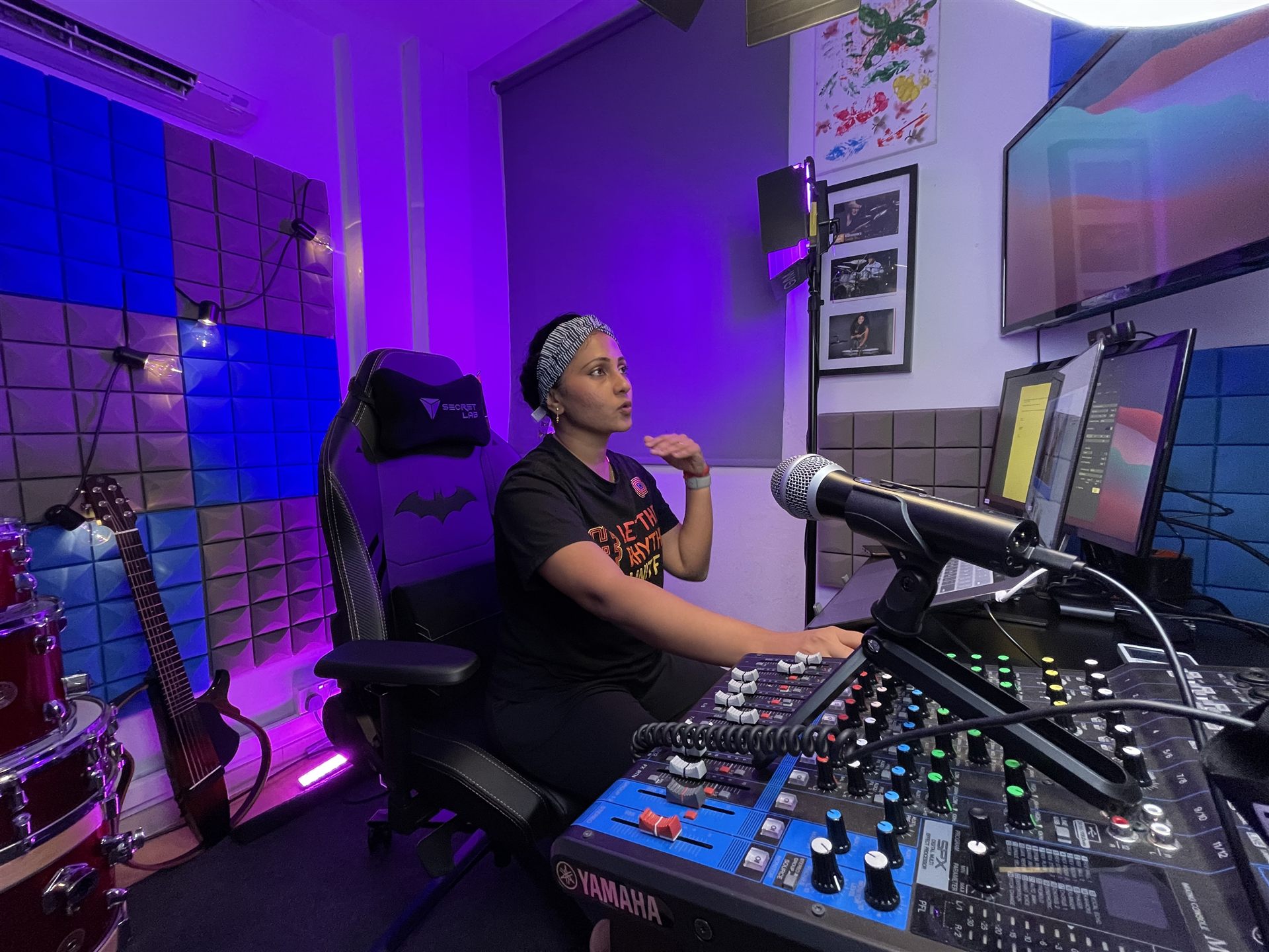 An instructor leading an online drum lesson from a home studio